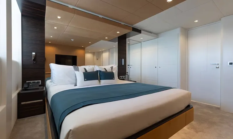 Orion: Double cabin with teal throw, dark wood panels and white wardrobes