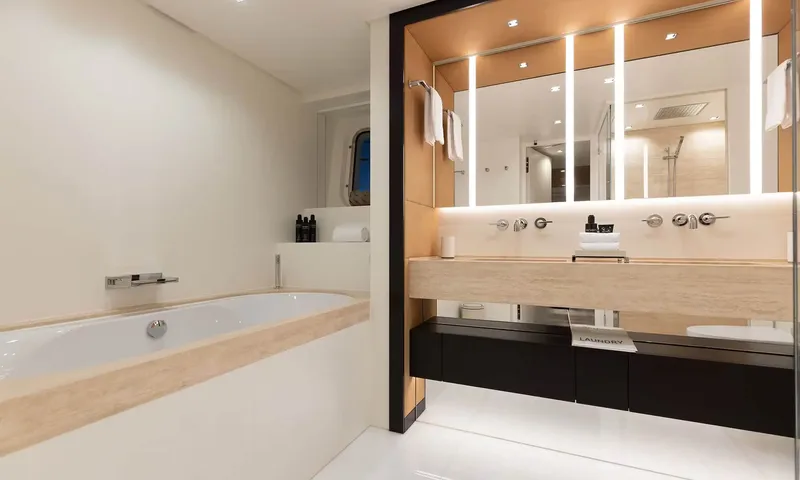 Orion: Bathroom with bathtub, double sink vanity and lit mirror