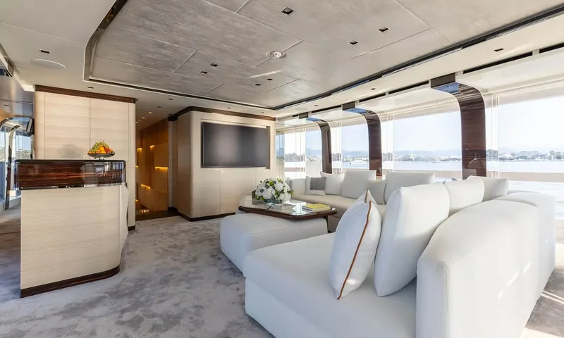 Orion: Lounge with curved white sofas, coffee table, wall screen and large side windows