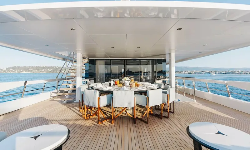 Orion: Shaded aft deck with round dining table, director chairs and sea views