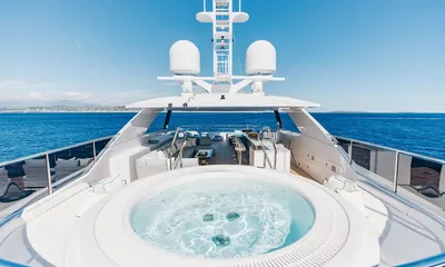 Orion: Round jacuzzi on the top deck with bar and seating beyond under a radar arch