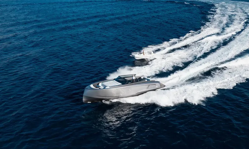 Orion: Grey tender speeding across deep blue sea followed by a smaller white boat