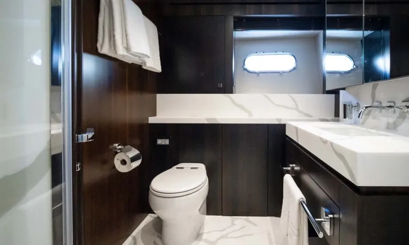 Nigora: Ensuite with toilet, marble effect basin, dark wood walls and portholes