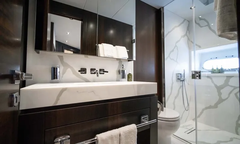 Nigora: Ensuite with marble effect basin, dark wood cabinet, toilet and glass shower