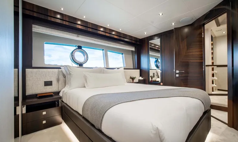 Nigora: Double cabin with white bedding, grey throw and wide hull window