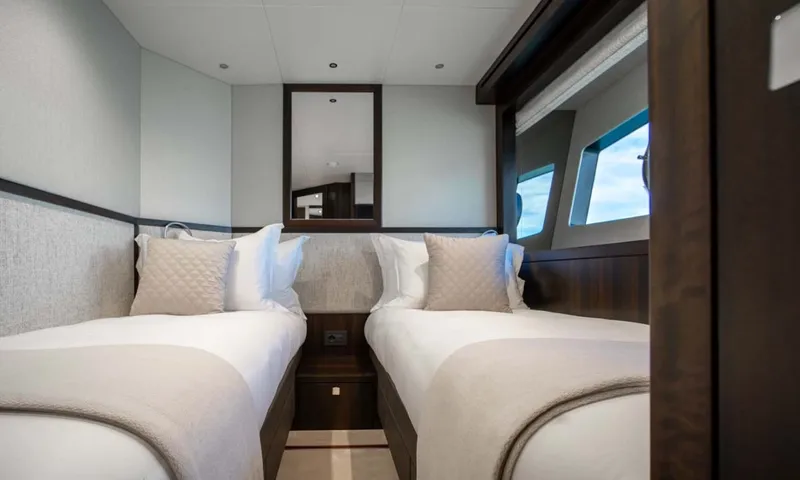 Nigora: Twin cabin with two single beds, cushions and a mirror between