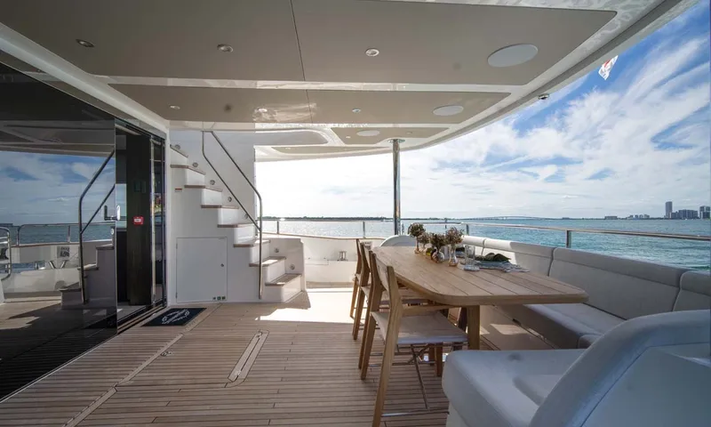 Nigora: Shaded aft deck with teak dining table, bench seating and stairs to the upper deck