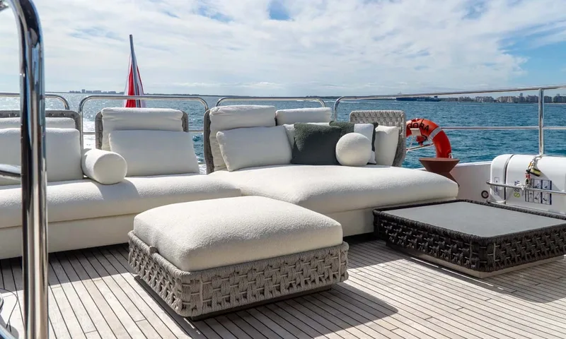 Nigora: White cushioned lounge sofa, ottoman and woven coffee table on a teak upper deck