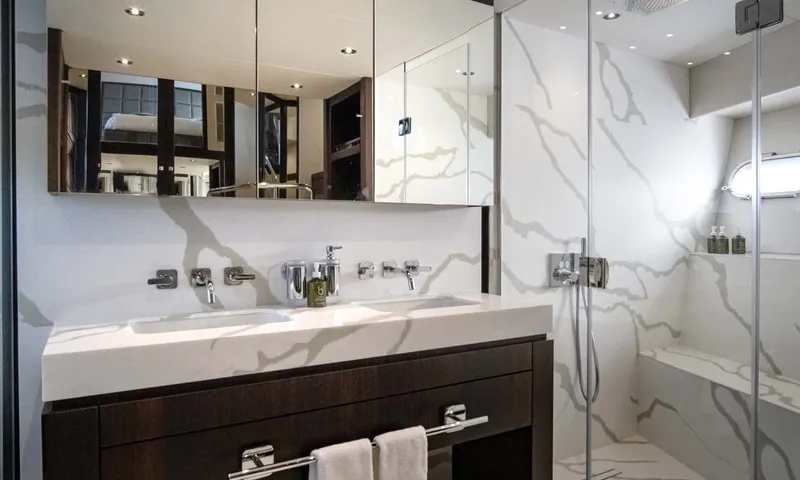 Nigora: Bathroom with double basin vanity, mirrored cabinets and marble effect shower