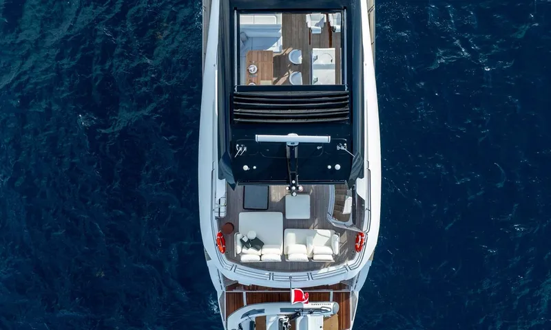 Nigora: Overhead drone view of the yacht's top deck and stern on deep blue water